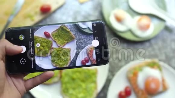 用荷包蛋拍摄健康鳄梨鲑鱼bruschetta的照片移动食品摄影理念视频的预览图