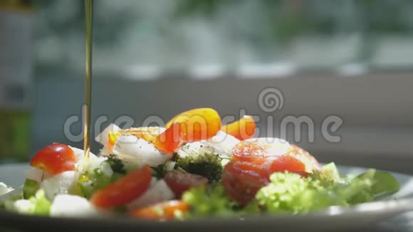 在新鲜的春色拉上倒入橄榄油天然素食沙拉有机食品的健康生活方式视频的预览图