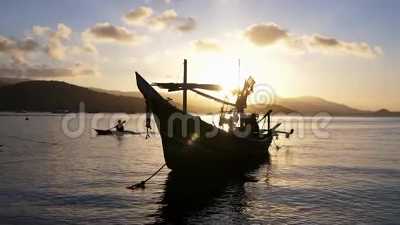 船靠近岸映衬着山峦和美丽的夕阳浪漫的气氛镇静和安抚视频的预览图