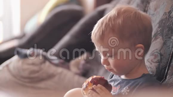 小男孩正在吃一个红苹果健康饮食健康食品视频的预览图