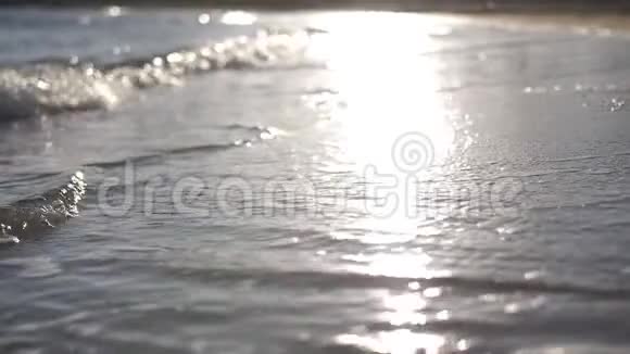 西班牙日落时海滩上的波浪带泡沫的慢波视频的预览图