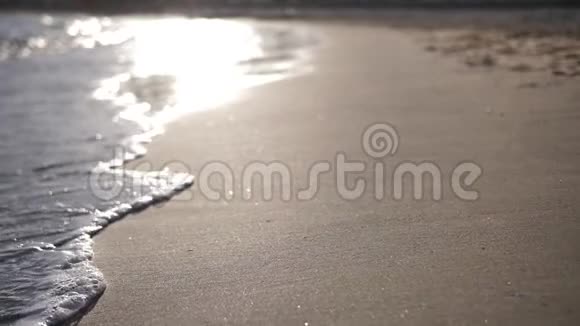 西班牙日落时海滩上的波浪带泡沫的慢波视频的预览图