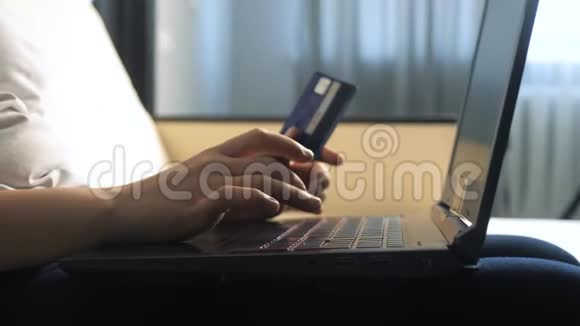 女孩用数字平板电脑制作网上销售购物概念黑发女人躺在沙发上看着网上支付的商店视频的预览图