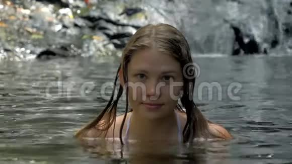 在森林里的池塘里洗澡的美女肖像背景是小瀑布视频的预览图