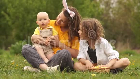 妈妈和她的两个儿子在公园野餐家庭周末孩子和母亲望着远方笑了起来视频的预览图