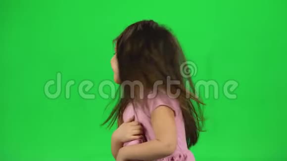 可爱的小女孩在绿色屏幕上玩耍做一张滑稽的脸视频的预览图