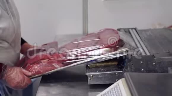 肉贩的特写镜头把鲜肉放在肉铺一个托盘上视频的预览图
