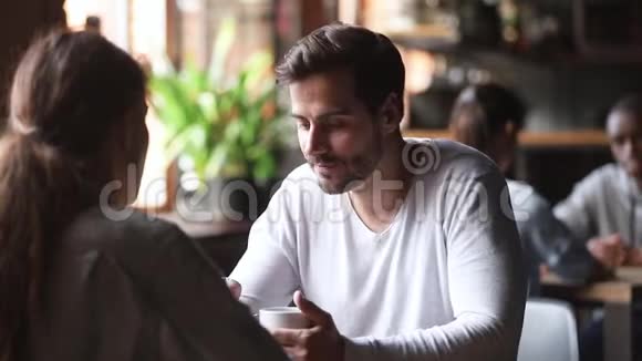 与女人交谈的年轻人坐在咖啡馆的桌子上视频的预览图