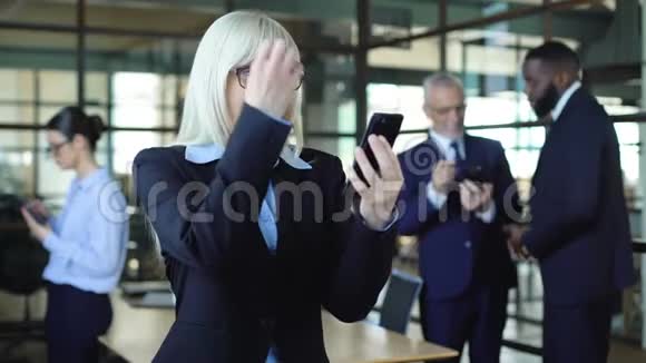 兴奋的商务女性智能手机显示成功的姿态股票交易应用程序视频的预览图