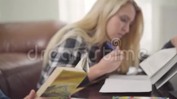 年轻夫妇在家读困难的书一个黑发男人和金发女人讨论材料的肖像视频的预览图