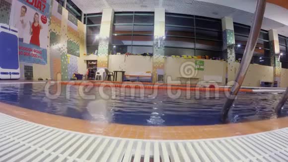 戴红色泳帽的人在游泳池游泳爬行的侧景视频的预览图