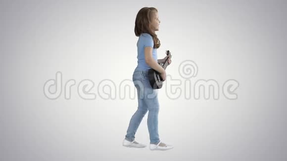 可爱的小女孩走路和唱歌同时在四弦琴上演奏梯度背景视频的预览图