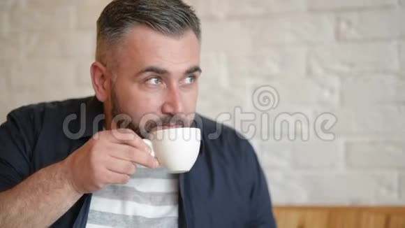穿着正式服装的快乐白种人商人微笑着看着他的智能手机屏幕一边喝着咖啡视频的预览图