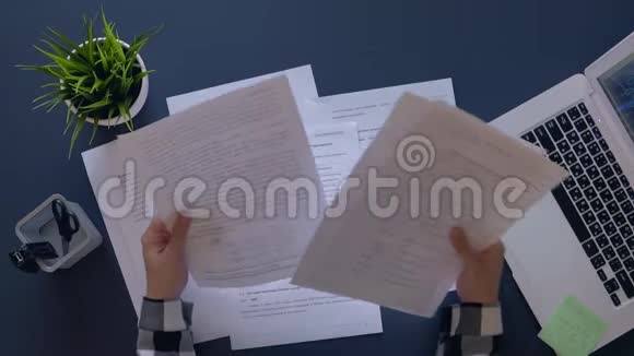 一个心情不好的女孩坐在一张桌子旁分析文件把它们举着头扔上去慢动作视频的预览图