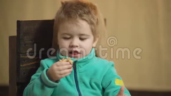 一个男孩吃披萨竖起大拇指的特写肖像美味的披萨可爱的白人小男孩吃披萨视频的预览图