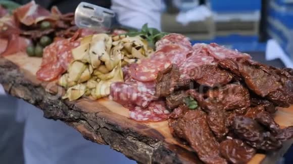 美味的香肠肉和薄薄的切片肉在一个木板上招待客人餐饮服务自助餐厅视频的预览图
