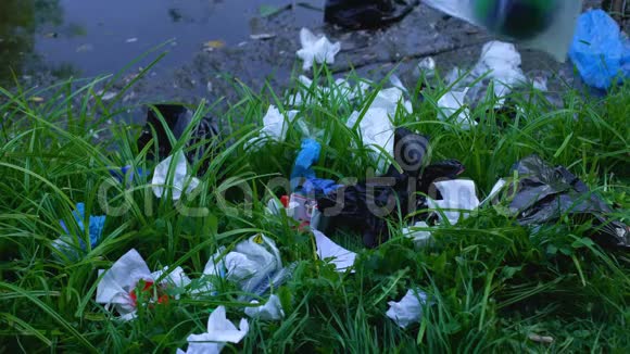 在森林沼泽附近的露天倾倒垃圾的塑料袋里用手投掷地球仪视频的预览图