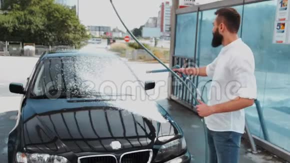 司机用软管清洗黑色汽车视频的预览图