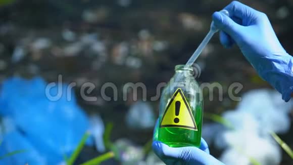 生态学家从带有警告标志的瓶子中抽取液体样本污染区视频的预览图