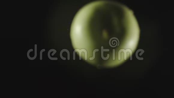 俯视图绿苹果掉进水里溅起水花慢动作视频的预览图
