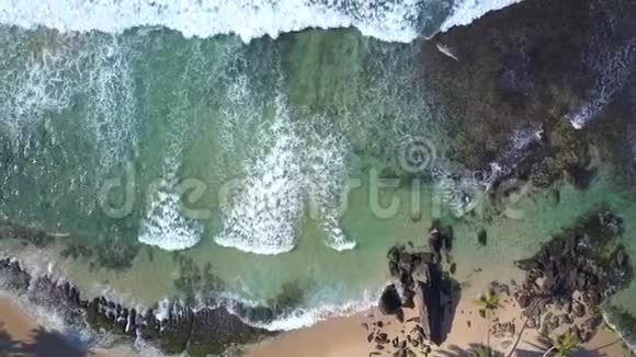 海浪在沙质的海岸线上翻滚棕榈树和建筑物视频的预览图