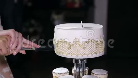 新婚夫妇切了一个漂亮的白色结婚蛋糕特写镜头视频的预览图
