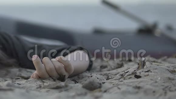 沉船悲剧后躺在海边的死去女人手的特写镜头视频的预览图