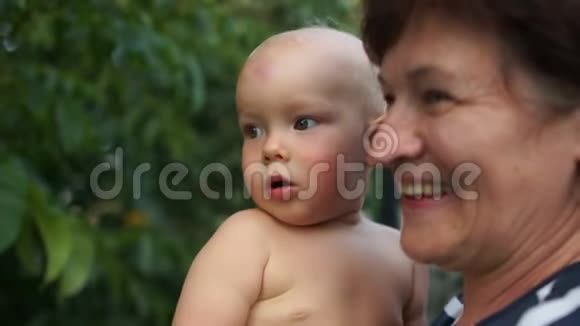 微笑的祖母和孙子的近照成熟的女人抱着一岁的孩子在视频的预览图