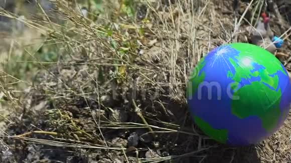 地球球躺在垃圾填埋场附近的草地上环境危害意识危害视频的预览图
