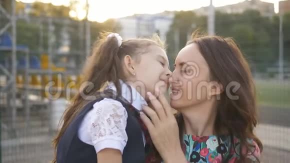 妈妈从学校遇到一个小女儿把她抱在怀里拥抱和亲吻视频的预览图