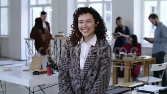 美丽的肖像年轻的欧洲商务妇女触摸卷发正式西装微笑快乐在现代办公室视频的预览图