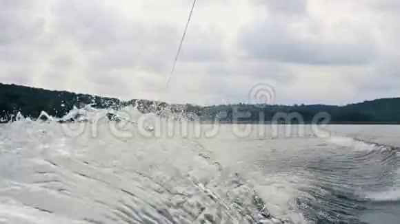 极限水上运动年轻人在湖边的尾灯上玩把戏滑雪板骑手在水中快速移动视频的预览图