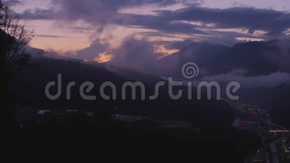 黄昏时鸟瞰多云的山观光甲板上的游客视频的预览图