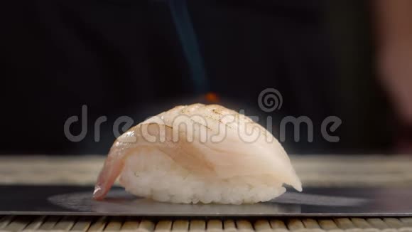 生鱼被燃气燃烧器缓慢地烤焦用米饭和鲈鱼做寿司卷煮生鱼视频的预览图