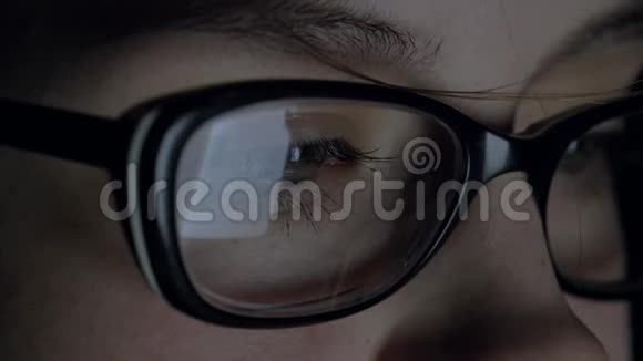 女人在夜晚使用平板电脑眼镜上反射的屏幕视频的预览图