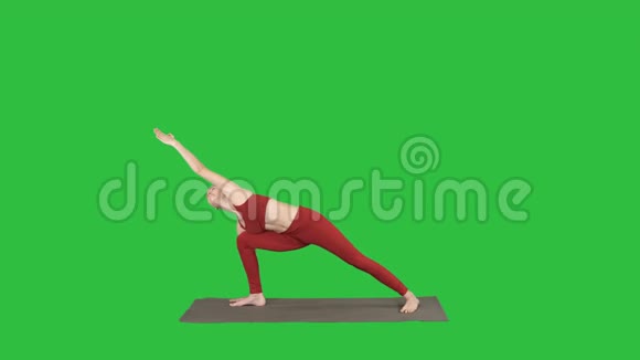 年轻女性练习瑜伽完成在绿色屏幕上的Utthitaparsvakonasana锻炼Chroma键视频的预览图