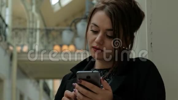 漂亮的中年黑发女人穿着黑色外套通过电话交谈视频的预览图