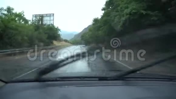 在潮湿的道路上雨中驾驶汽车车窗外的雨天视频的预览图