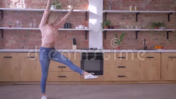 快乐活泼的女孩在厨房慢动作地做体操翻转动作视频的预览图