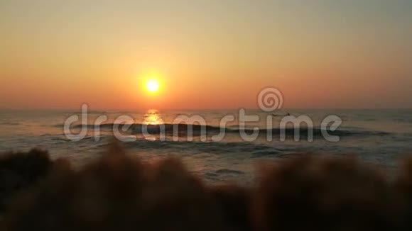海滩上金色的阳光云和太阳背后明亮的金黄色太阳海水中阳光的反射乌云视频的预览图