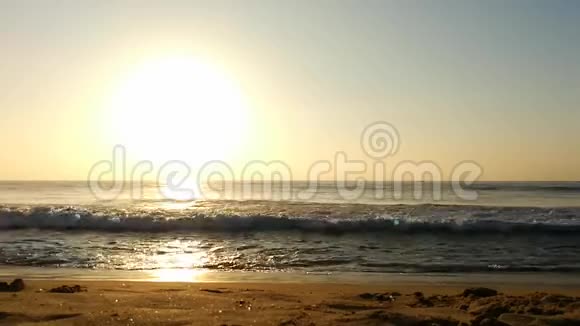 海滩沙滩和蓝色海洋上的贝壳云和太阳背后的金色太阳海水的日光反射乌云视频的预览图