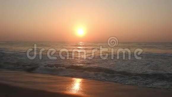 金色的阳光反射在海滩上太阳在傍晚照耀着海浪在岸边拍打海滩上的金色阳光红太阳视频的预览图