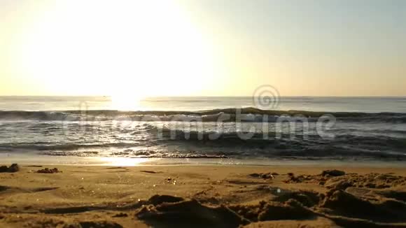 海滩上金色的阳光在云和阳光的背后明亮的金黄色太阳海水上的阳光反射乌云视频的预览图