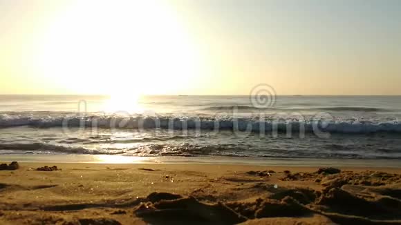 海滩上金色的阳光在云和阳光的背后明亮的金黄色太阳海水上的阳光反射乌云视频的预览图