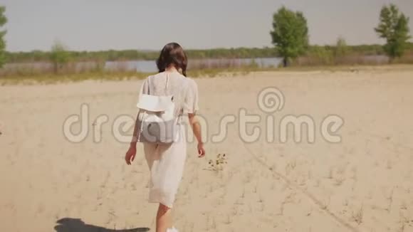 散步海滩上的快乐女人背面视频的预览图