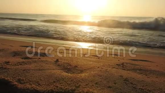 海滩上五彩缤纷的金色日落落日余晖映在大海和沙滩上五颜六色的海滩日出与阳光视频的预览图