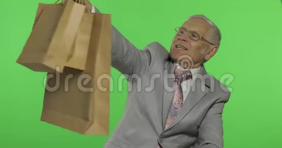 快乐的老人带着购物袋购物后穿正式服装的老人视频的预览图