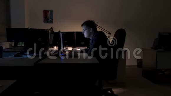 勤劳的年轻商人在他的办公桌上寻找他电脑屏幕上的信息侧视股票视频的预览图