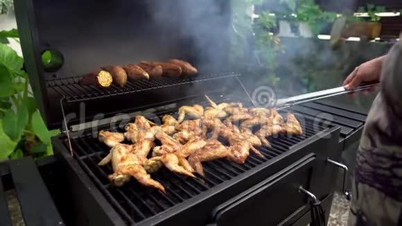 4在烧烤时用火钳转动美味的辣鸡翅视频的预览图