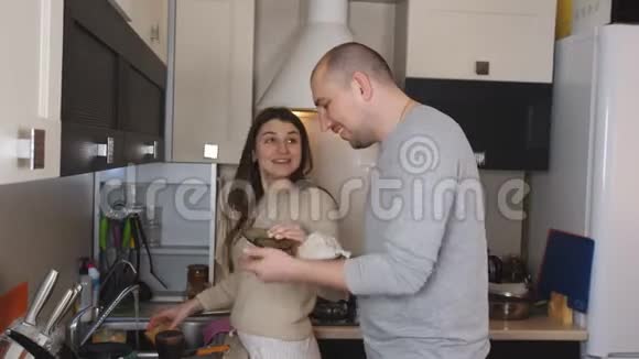 可爱的年轻夫妇微笑着一起洗碗视频的预览图
